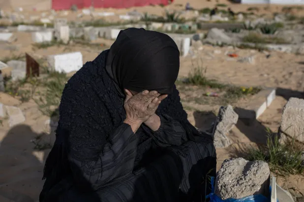 فلسطينية تبكي لدى زيارة قبور أقاربها في خان يونس جنوب قطاع غزة... الجمعة (إ.ب.أ)