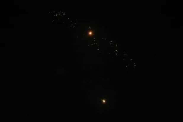  Streaks of fire and light cross the night sky as an Israeli interceptor strikes an Iranian missile amid the US-Israeli conflict with Iran, over Tel Aviv, Israel, March 18, 2026. (Reuters)