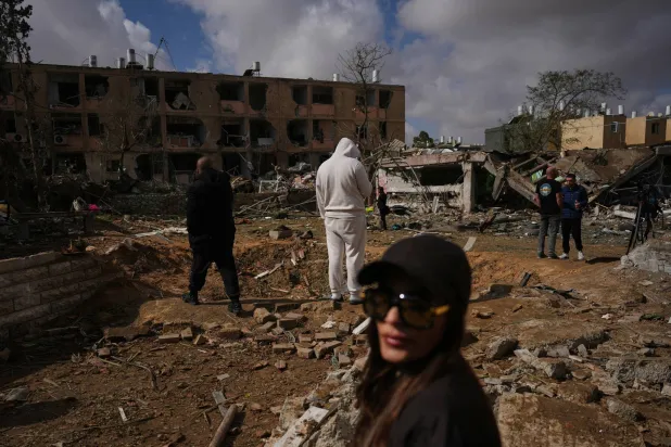 مواطنون يتفقدون أثر سقوط صاروخ إيراني في ديمونة جنوب إسرائيل اليوم (أ.ب)