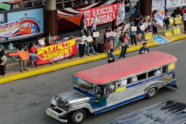 حافلة «جيبني» الشعبية تمر بجانب متظاهرين في مانيلا يعارضون ارتفاع أسعار الوقود المرتبط بحرب إيران (إ.ب.أ)