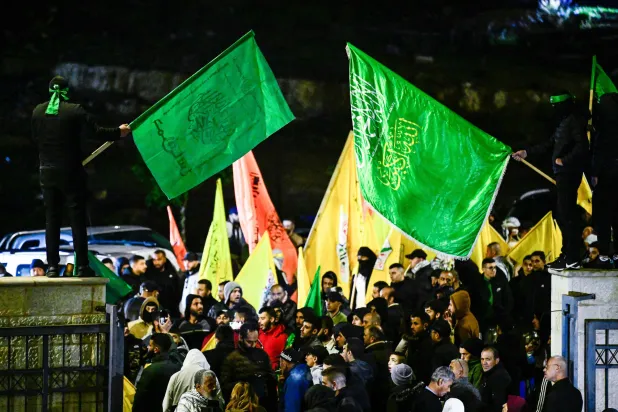 فلسطينيون يلوحون بأعلام «حماس» خلال استقبال أسرى فلسطينيين في رام الله بالضفة الغربية نوفمبر 2023 (أ.ف.ب)