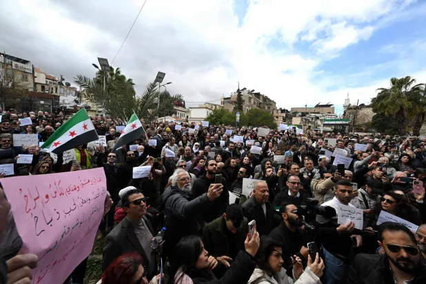 سوريون ينفذون اعتصاماً صامتاً احتجاجاً على قرار السلطات تقييد بيع المشروبات الكحولية في حي باب توما بدمشق اليوم (أ.ف.ب)