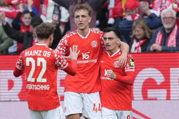 Mainz' scorer Paul Nebel, right, and his teammates Nelson Weiper, center, and Nikolas Veratschnig, left, celebrate their side's second goal during the German Bundesliga soccer match between 1.FSV Mainz 05 and Eintracht Frankfurt in Mainz, Germany, Sunday, March 22, 2026. (Marc Schueler/dpa via AP)
