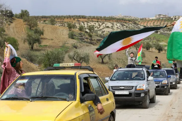 رفع الأكراد السوريون أعلام كردستان خلال احتفالات عيد النوروز في عفرين بريف حلب السبت (رويترز)