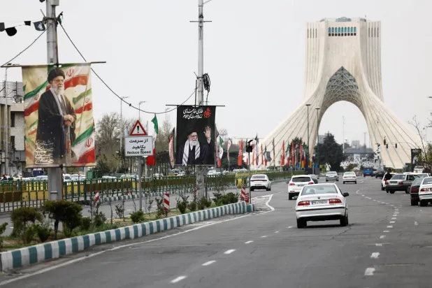 تُعرض لافتات تحمل صورة المرشد الإيراني الراحل علي خامنئي في أحد شوارع طهران وسط التوتر القائم بين الولايات المتحدة وإسرائيل وإيران (رويترز)