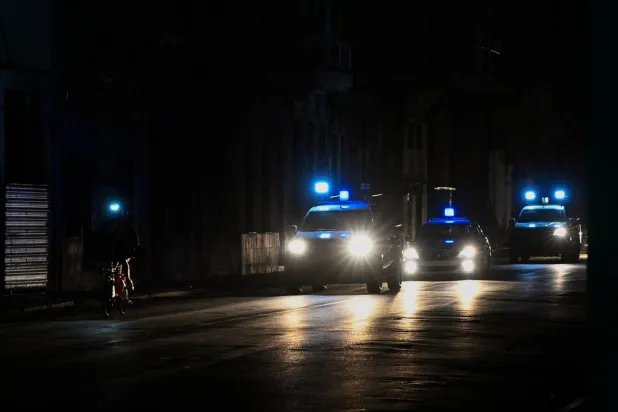 سيارات الشرطة تجوب شارعاً معتماً خلال انقطاع التيار الكهربائي الشامل في هافانا (أ.ف.ب)
