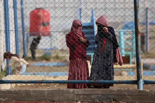 Suriye'nin kuzeydoğusundaki Roj kampının duvarları ardında DEAŞ üyelerinden ikisinin eşleri (AP)