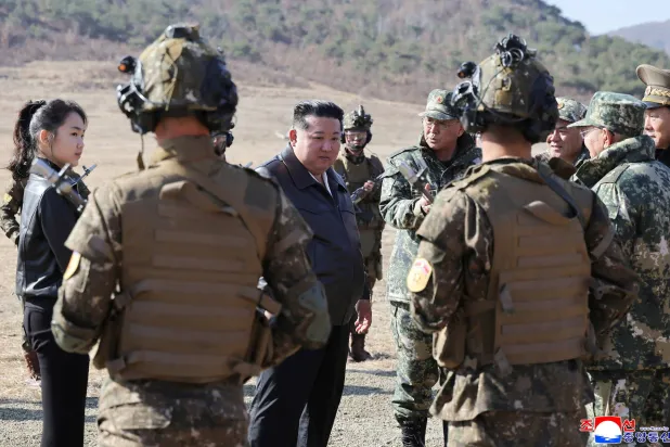 الزعيم الكوري الشمالي كيم جونغ أون وابنته وسط مجموعة من الجنود خلال تدريب تكتيكي في بيونغ يانغ (رويترز)