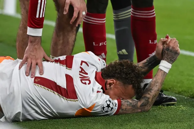 Galatasaray's Dutch forward #77 Noa Lang reacts on the floor after cutting his thumb during the UEFA Champions League, round of 16 second leg football match between Liverpool and Galatasaray at Anfield in Liverpool, northwest England on March 18, 2026. (AFP)