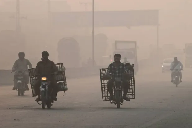  Commuters make their way amid smog in Lahore on November 2, 2024. (AFP)