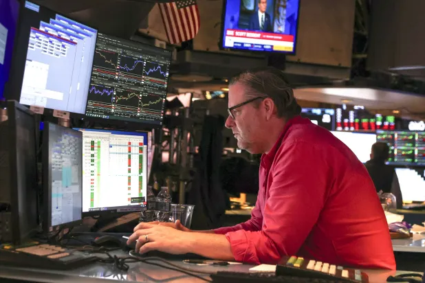 متداول يراقب شاشات تعرض مؤشرات الأسهم في بورصة نيويورك (إ.ب.أ)