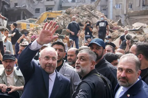  Iran's parliament speaker Mohammad Bagher Qalibaf, left, waves to residents as he visits the site of an Israeli airstrike in Beirut, Lebanon, on Oct. 12, 2024. (AP)