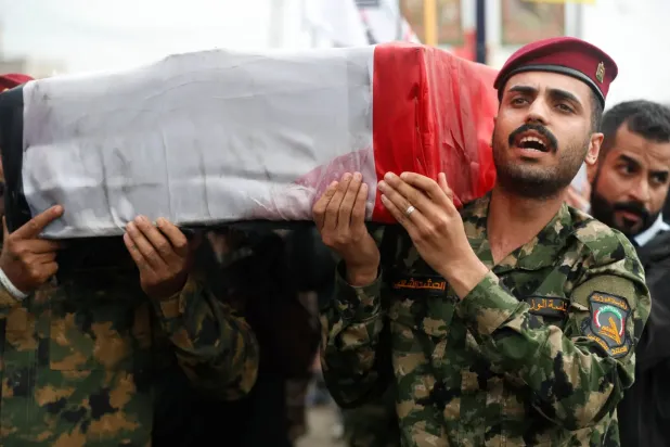 Haşdi Şabi mensupları, 24 Mart 2026'da Bağdat'ta Enbar Operasyonları Komutanı'nın cenaze töreninde tabutu taşıyor (AFP)