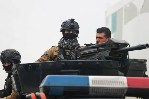 Members of Iraq’s PMF guard the streets during the funeral for members of the PMF in Baghdad on March 24, 2026. (AFP)
