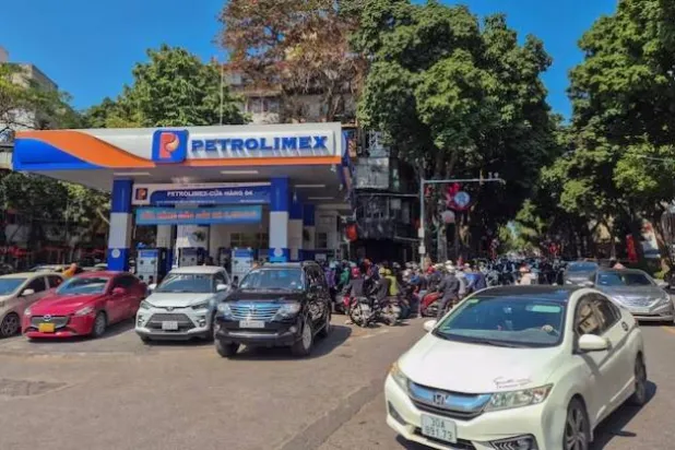 أشخاص يصطفون لشراء البنزين في محطة وقود في هانوي (رويترز)