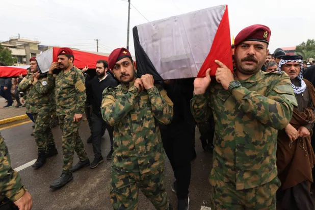 Members of Iraq's PMF carry the coffin of the PMF operations commander for Al-Anbar, Saad Dawai alongside others during a mass funeral in Baghdad on March 24, 2026. (AFP) 
