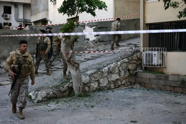 جنود من الجيش اللبناني يقفون في الموقع الذي سقطت فيه شظايا صاروخ تم اعتراضه بمنطقة حارة صخر بقضاء كسروان شمال بيروت 24 مارس 2026 (إ.ب.أ)