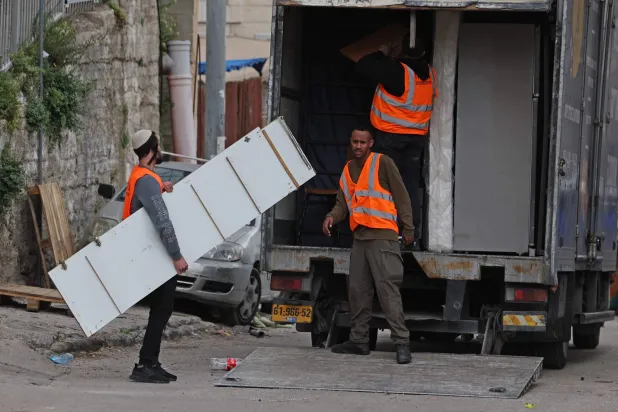 إسرائيليون يزيلون مقتنيات منزل فلسطيني خلال إخلاء 11 عائلة من منطقة بطن الهوى في حي سلوان بالقدس الشرقية (أ.ف.ب)