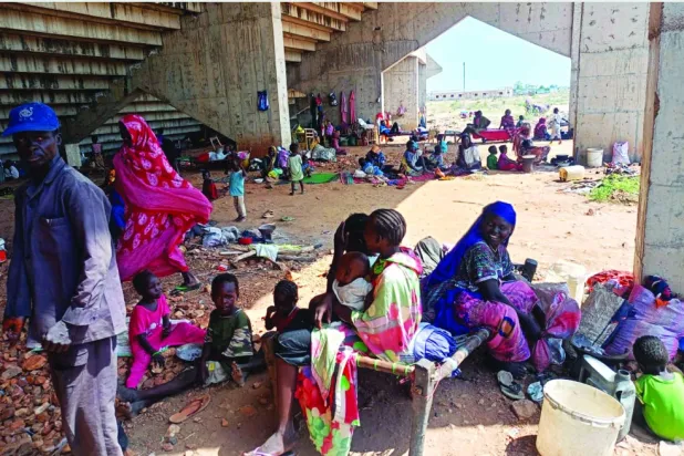 Displaced Sudanese families from Kurdufan at a football stadium in the town of Kadugli, south of the region (AP)