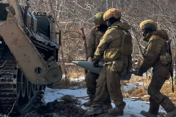 جنود روس وهم يحملون ذخيرة لمدفع بيون ذاتي الحركة عيار 203 ملم استعداداً لإطلاق النار باتجاه موقع أوكراني في 23 مارس 2026 (أ.ب)