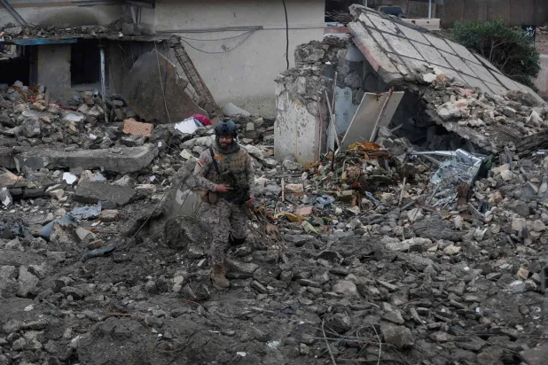 An Iraqi soldier stands guard at the site of a destroyed healthcare center in the Habbaniyah military base, which was targeted by in an airstrike killing seven security personnel and wounding 13 others, in Habbaniyah, west of Baghdad on March 26, 2026. (AFP)