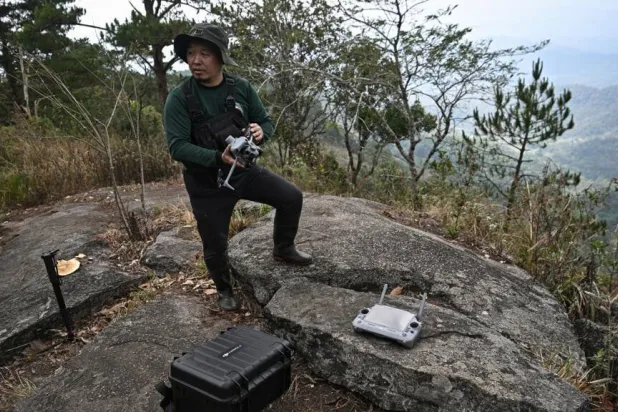 Hmong volunteer firefighter Mongkol Yingyotmongkolsaen using a drone to monitor fires in the Doi Suthep-Pui National Park area of Chiang Mai. Lillian SUWANRUMPHA / AFP
