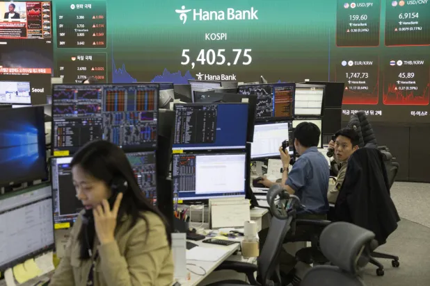 متداولون يعملون أمام شاشات تعرض مؤشرات الأسهم في بنك «هانا» بسيول (إ.ب.أ)