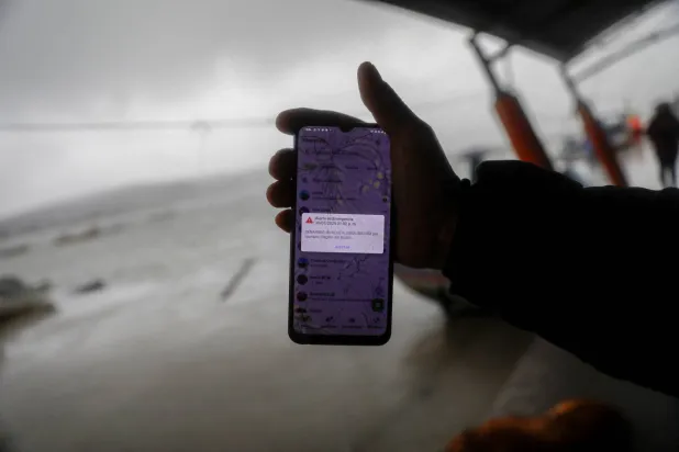 A person shows a cell phone displaying a message to evacuate to a tsunami safety zone during an evacuation of the coast following a tsunami warning issued by local authorities after an earthquake struck the Kamchatka Peninsula in the far east of Russia, triggering warnings and evacuations across the South Pacific, in Dichato, near Concepcion, Chile, July 30, 2025. (Reuters)