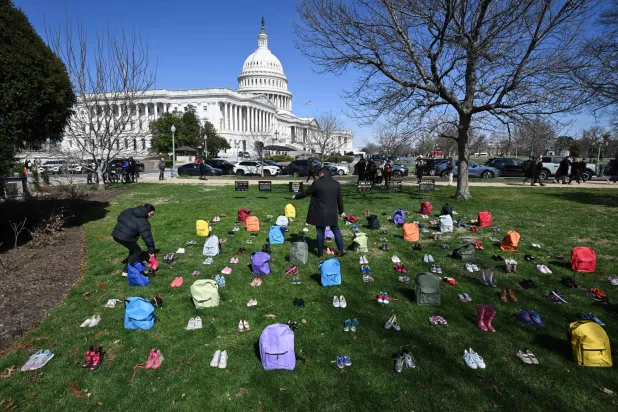نُصب تذكاري من أحذية وحقائب ترمز إلى ضحايا تفجير مدرسة ميناب الابتدائية في إيران... أمام مبنى الكابيتول الأميركي في العاصمة واشنطن في 18 مارس 2026 (أ.ف.ب)