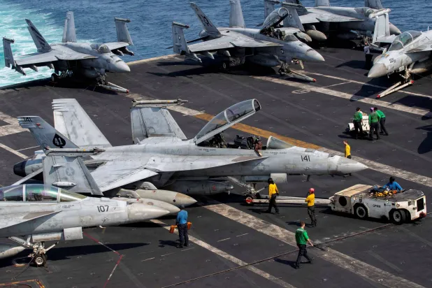 US Navy sailors taxi an F/A-18F Super Hornet on the flight deck aboard Nimitz-class aircraft carrier USS Abraham Lincoln in support of the Operation Epic Fury attack on Iran from an undisclosed location March 17, 2026. (US Navy/Handout via Reuters) 