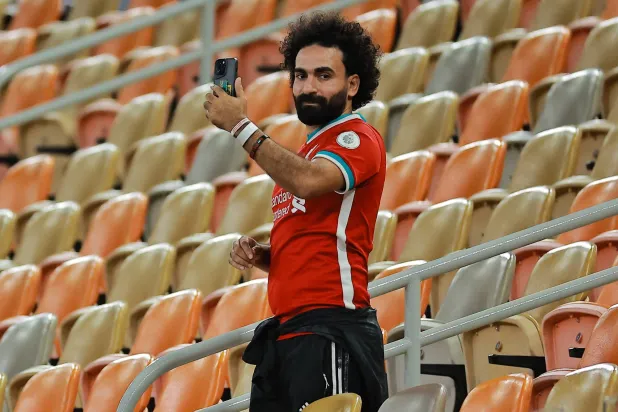 المشجع المصري شبيه النجم محمد صلاح يوثّق الحدث بهاتفه (رويترز)