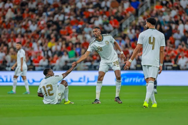 سعود عبد الحميد يتلقى مساعدة من زميله محمد كنو لحظة سقوطه على أرض الملعب خلال المباراة (تصوير: محمد المانع) 