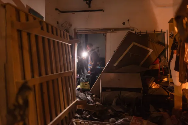 أحد أعضاء فريق الإنقاذ الإسرائيلي يتفقد الأضرار الناجمة عن هجوم صاروخي إيراني على تل أبيب (د.ب.أ)