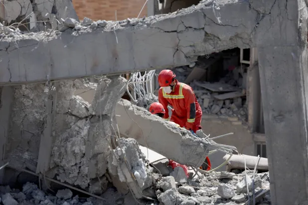 Iranian firefighters work on a damaged residential building in southern Tehran, Iran, 27 March 2026.EPA/ABEDIN TAHERKENAREH
