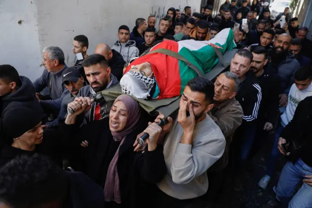 والدة الفتى الفلسطيني أدهم سيد صالح دهمان تقود جنازته في بيت لحم بالضفة الغربية المحتلة (رويترز)