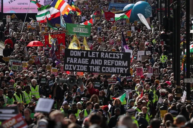 A large crowd of protesters holding up signs and banners. Photograph: Hannah McKay/Reuters