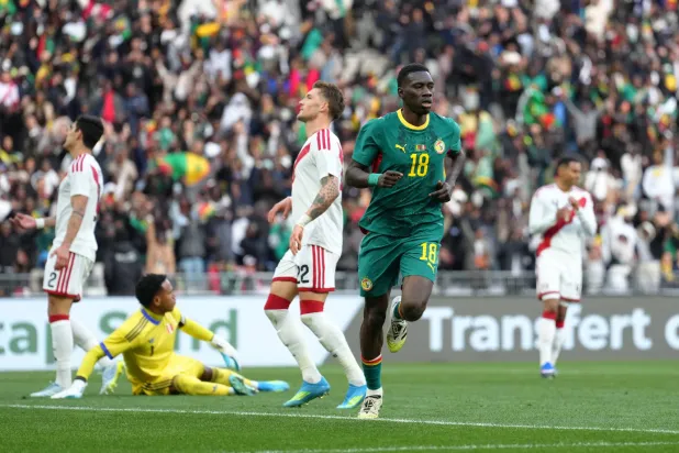 إسماعيلا سار يحتفل بعد تسجيله الهدف الثاني للسنغال في بيرو (أ.ب)