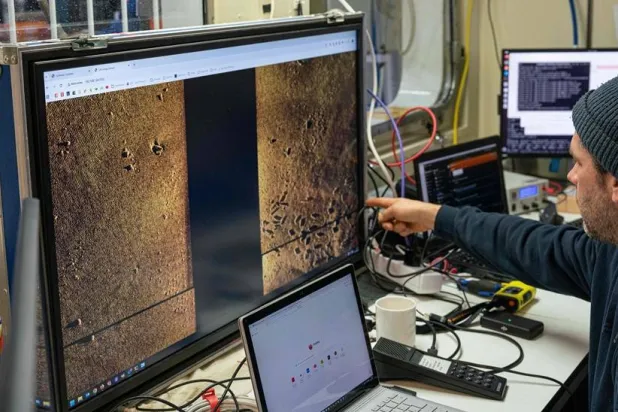 This handout photo taken on March 16, 2026 and released by the Kiel-based GEOMAR oceanographic research center on March 23, 2026 shows a scientist looking at digital scans highlighting munitions and various spots of interest on the seabed aboard the scientific research vessel Alkor in the Eastern Baltic Sea. (Lauren Peck / GEOMAR / AFP) 