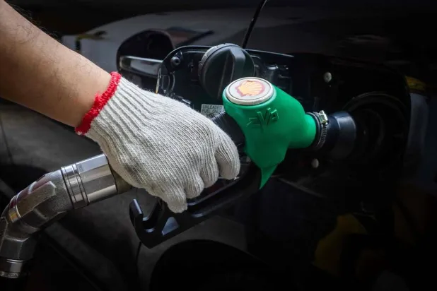 A worker refills the tank of a car at a gasoline station in Macau on March 27, 2026. (AFP) 