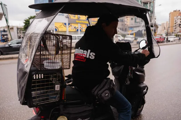 عضو من فريق إنقاذ تابع لمنظمة «أنيمالز ليبانون» يتجه إلى ضاحية بيروت الجنوبية في 26 مارس (أ.ف.ب)