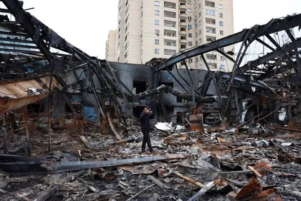 Members of the media work amid wreckage of vehicles at an auto service center in Tehran, Iran, 28 March 2026. (EPA)