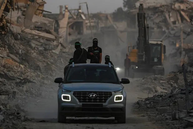 Fighters of the Qassam Brigades, the military wing of the Hamas movement, stand guard as they search for the bodies of Israeli hostages alongside Red Cross workers in Al Shejaeiya neighborhood in the east of the Gaza City, Gaza Strip, 05 November 2025.  (EPA)