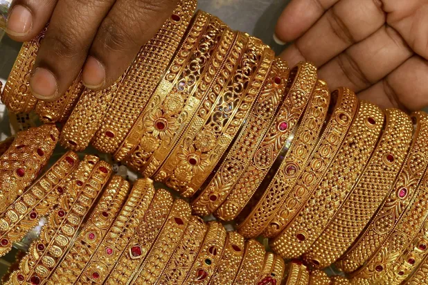An Indian woman displays a gold jewelry piece at a jewelry store in Bangalore (AFP)