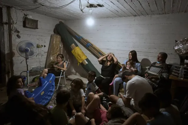 Israelis take shelter during air raid sirens warning of incoming strikes by Iran, in Bnei Brak, near Tel Aviv, Israel, Tuesday, June 17, 2025. (AP Photo/Oded Balilty)