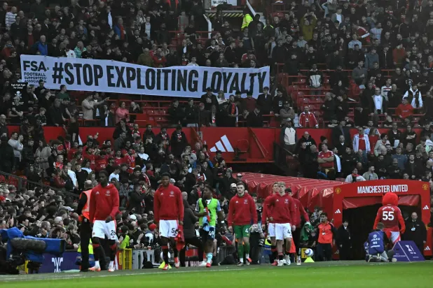 Manchester United fans, many wearing black as a protest, display a banner in the crowd against seat prices and the current ownership of Manchester United ahead of the English Premier League football match between Manchester United and Arsenal at Old Trafford in Manchester, northwest England, on March 9, 2025. (AFP)