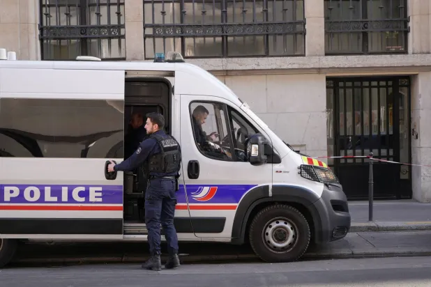Police stand outside the Bank of America building in Paris, Saturday, March 28, 2026. (AP Photo/Nicolas Garriga)
