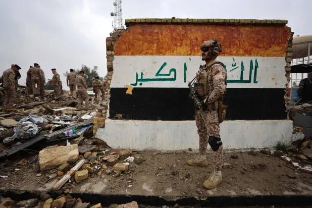 Iraqi soldiers inspect the site of a destroyed healthcare center in the Habbaniyah military base, which was targeted by in an airstrike killing seven security personnel and wounding 13 others, in Habbaniyah, west of Baghdad on March 26, 2026. (AFP)