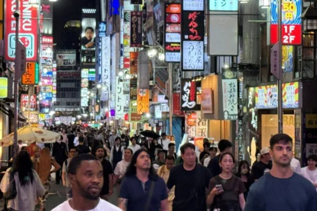 أشخاص يتجولون بمنطقة تسوق في طوكيو (رويترز)