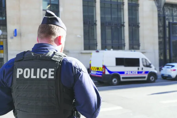 Police stand outside the Bank of America building in Paris, Saturday, March 28, 2026. (AP Photo/Nicolas Garriga)