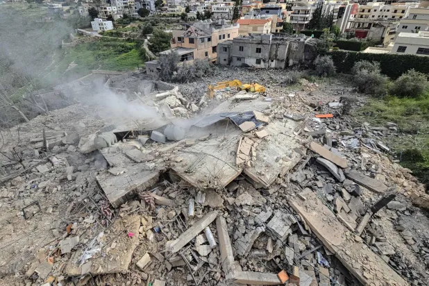 First responders work on the rubble of a building targeted by an Israeli airstrike in the southern Lebanese village of Hanouiyeh, east of Tyre, on March 30, 2026. (AFP)